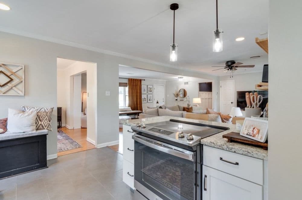 Modern kitchen with granite countertops, stainless steel appliances, and open living space.