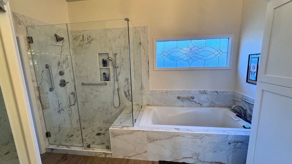 Elegant bathroom featuring a glass shower, soaking tub, and marble accents. Ideal for relaxation.