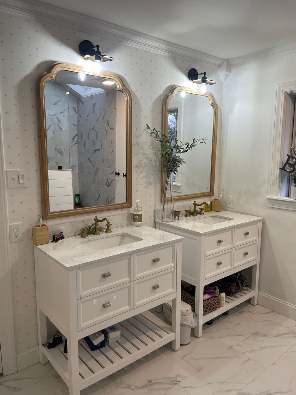 Modern bathroom with double vanity, large mirrors, and elegant lighting.