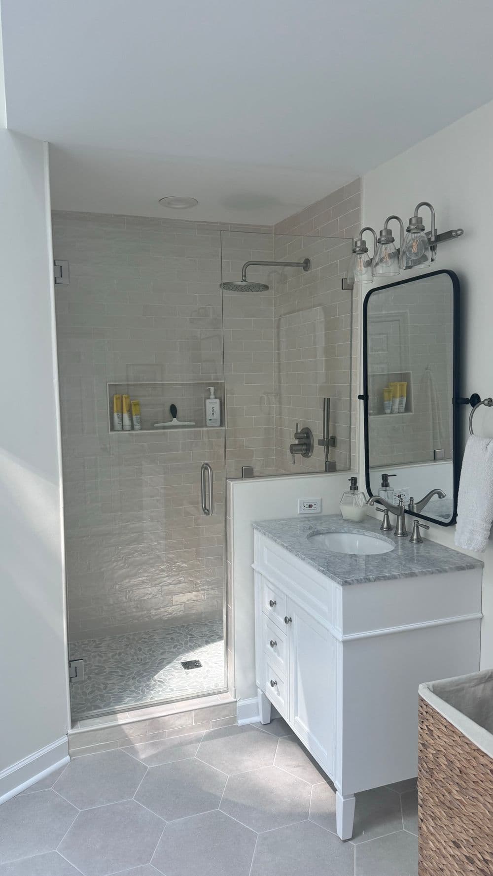 Modern bathroom with glass shower, marble vanity, and stylish fixtures. Bright, minimalist design.