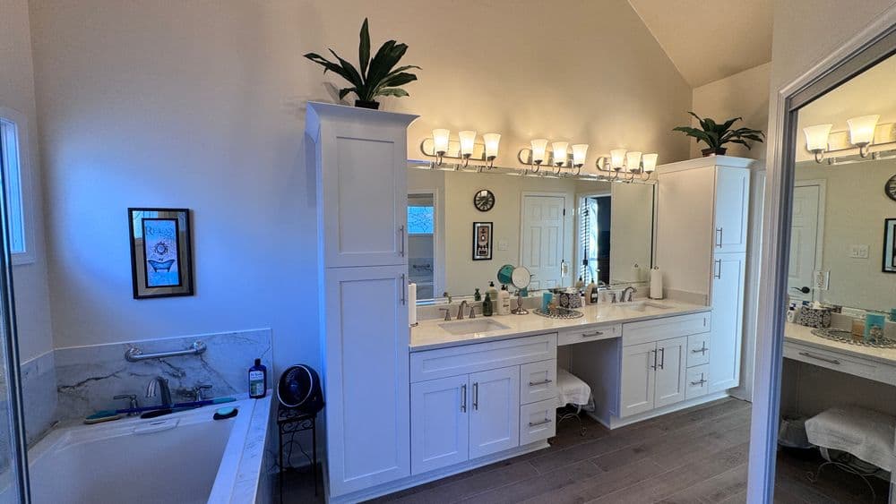 Spacious modern bathroom with double sinks, freestanding tub, and stylish lighting.