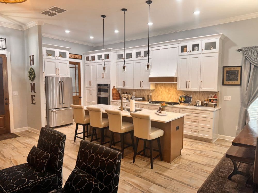 Modern kitchen with white cabinetry, large island, and stylish pendant lighting.